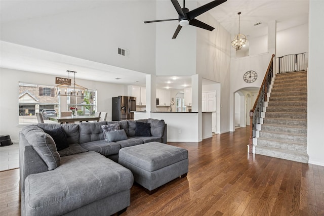 2708 Ferdinand, Grand Prairie, TX 75054 - living room with arched walkways, a chandelier, a ceiling fan, stairway, and dark wood-type flooring