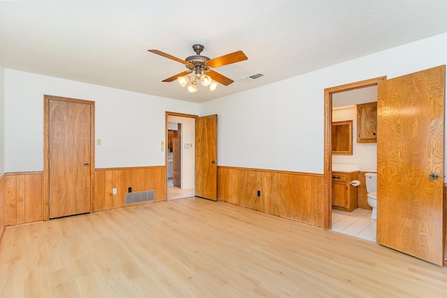 3004 Glasgow Dr, Arlington, TX 76015 - spare room with wainscoting, wood finished floors, wooden walls, and a ceiling fan