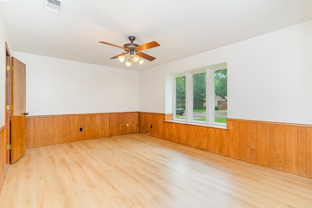 3004 Glasgow Dr, Arlington, TX 76015 - unfurnished room with a wainscoted wall, wood walls, wood finished floors, and a ceiling fan