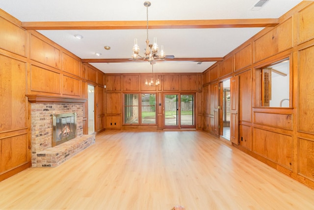 3004 Glasgow Dr, Arlington, TX 76015 - unfurnished living room with a chandelier, beam ceiling, light wood-style floors, wood walls, and a brick fireplace