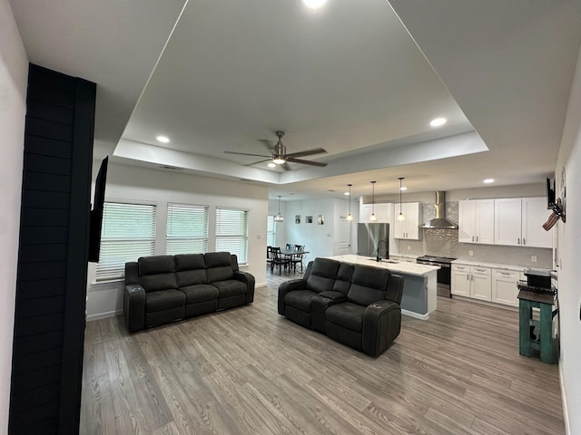 2352 Wynchase Ln, Crandall, TX 75114 - living area featuring a tray ceiling, a ceiling fan, light wood-type flooring, and recessed lighting