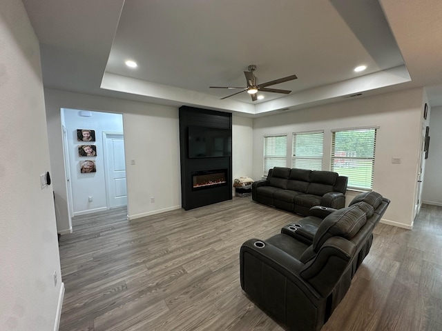 2352 Wynchase Ln, Crandall, TX 75114 - living area featuring a raised ceiling, a ceiling fan, wood finished floors, a fireplace, and recessed lighting