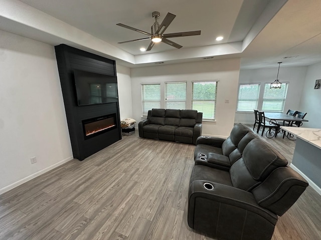 2352 Wynchase Ln, Crandall, TX 75114 - living area with a tray ceiling, a ceiling fan, light wood-type flooring, a large fireplace, and recessed lighting