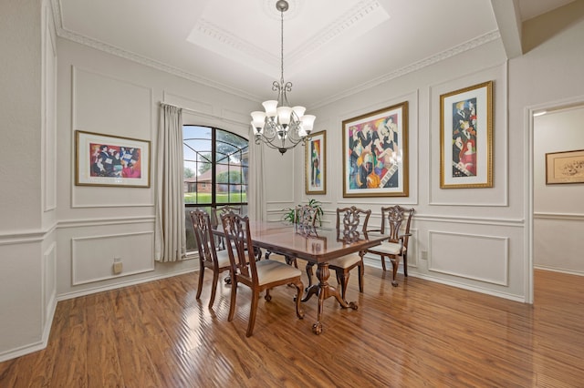 3121 Oakdale Dr, Hurst, TX 76054 - dining space with a decorative wall, wood finished floors, a chandelier, and ornamental molding