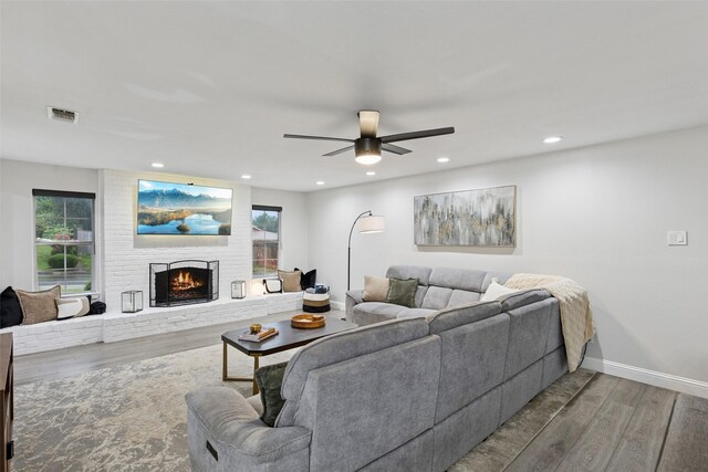 348 Thompson St, Fort Worth, TX 76134 - living area featuring wood finished floors, a brick fireplace, plenty of natural light, a ceiling fan, and recessed lighting