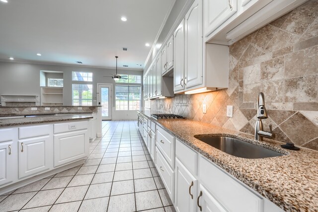 305 Wood Duck Ln, Mckinney, TX 75072 - kitchen with ceiling fan, tasteful backsplash, white cabinetry, light stone counters, and stainless steel gas stovetop