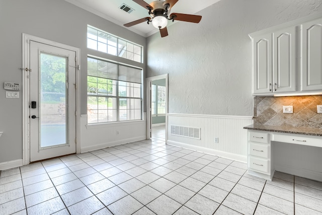 305 Wood Duck Ln, Mckinney, TX 75072 - unfurnished dining area with plenty of natural light, built in study area, a ceiling fan, light tile patterned floors, and a textured wall