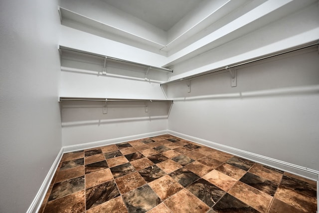 305 Wood Duck Ln, Mckinney, TX 75072 - walk in closet featuring dark stone finish floors