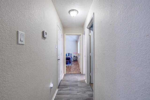 212 Valley Spring Dr, Arlington, TX 76018 - hall featuring a textured wall, wood finished floors, and a textured ceiling