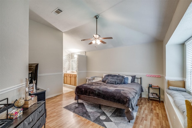 212 Valley Spring Dr, Arlington, TX 76018 - bedroom with light wood finished floors, vaulted ceiling, a ceiling fan, and connected bathroom