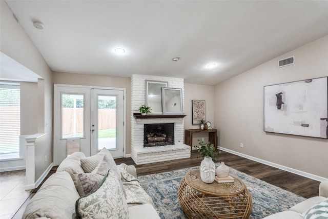 8688 Grenadier Ct, Dallas, TX 75238 - living room featuring vaulted ceiling, plenty of natural light, a brick fireplace, wood finished floors, and recessed lighting