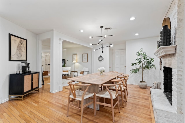 7845 Blackbird Ln, Dallas, TX 75238 - dining area with light wood-style flooring, recessed lighting, a fireplace, and a chandelier