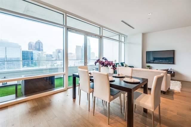 2430 Victory Park Ln Unit 1906, Dallas, TX 75219 - dining room with a wall of windows, wood finished floors, and a view of skyline