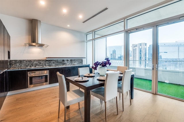 2430 Victory Park Ln Unit 1906, Dallas, TX 75219 - dining space featuring light wood-style flooring, a wall of windows, a view of city, and recessed lighting