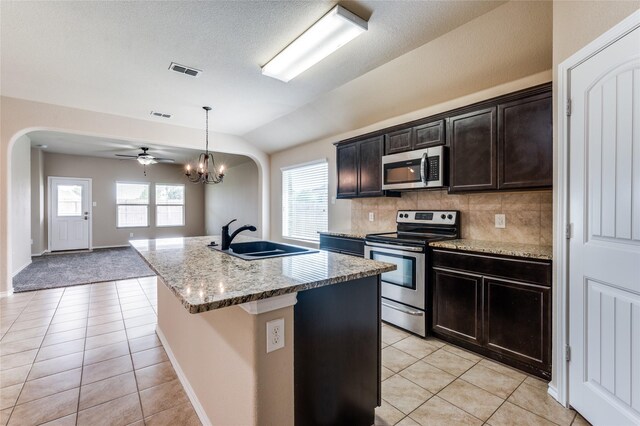 408 Citation Ln, Ponder, TX 76259 - kitchen with appliances with stainless steel finishes, arched walkways, light tile patterned floors, vaulted ceiling, and a ceiling fan