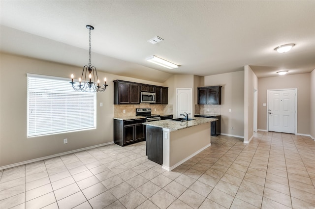 408 Citation Ln, Ponder, TX 76259 - kitchen with stainless steel appliances, decorative backsplash, light tile patterned flooring, a chandelier, and a kitchen island with sink