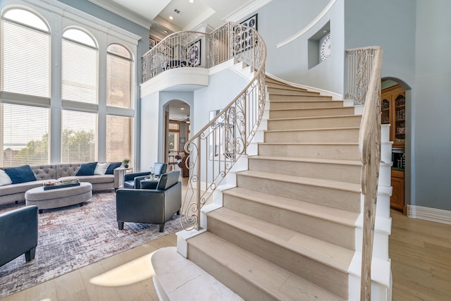 8800 Summit Point Ct, Fort Worth, TX 76179 - stairway with arched walkways, a towering ceiling, wood finished floors, and ornamental molding
