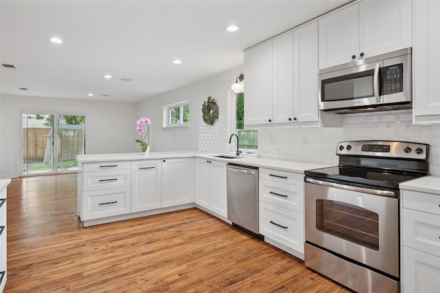 522 Carol Ct, Richardson, TX 75081 - kitchen with appliances with stainless steel finishes, a peninsula, light countertops, white cabinetry, and recessed lighting