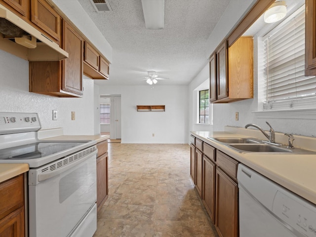 713 Brookhaven Dr, Royse City, TX 75189 - kitchen featuring white appliances, a ceiling fan, under cabinet range hood, brown cabinetry, and stone finish floors
