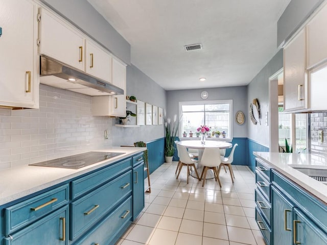 417 Merriman Dr, Highland Village, TX 75077 - kitchen featuring under cabinet range hood, black electric cooktop, blue cabinets, and white cabinetry