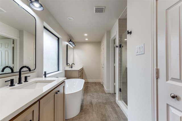 6404 Camille Ave, Dallas, TX 75252 - full bath with two vanities, a stall shower, a freestanding bath, and recessed lighting