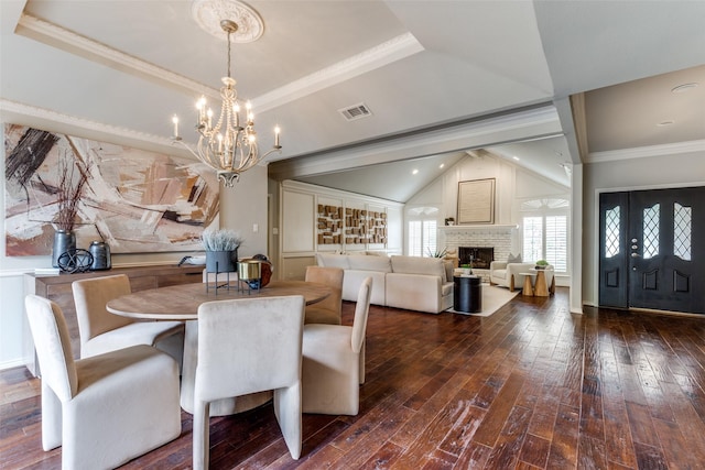 6404 Camille Ave, Dallas, TX 75252 - dining space with a chandelier, dark wood-style flooring, crown molding, and a brick fireplace