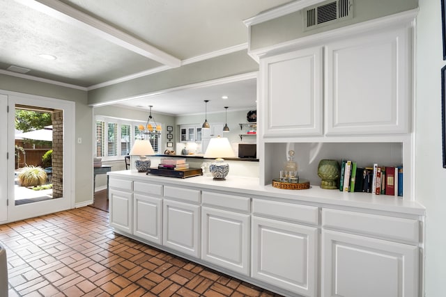 7120 Leameadow Dr, Dallas, TX 75248 - kitchen featuring brick patterned flooring, a peninsula, white cabinets, light countertops, and decorative light fixtures