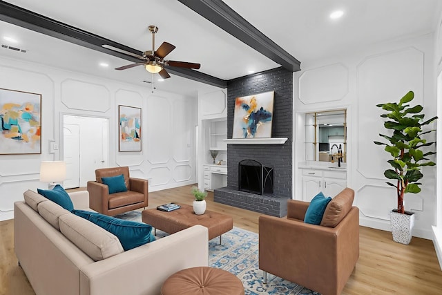 2258 Valley, Carrollton, TX 75006 - living room featuring light wood-type flooring, ceiling fan, a brick fireplace, recessed lighting, and beam ceiling