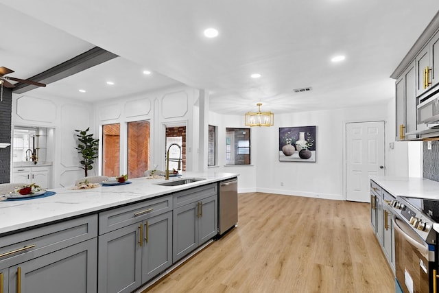 2258 Valley, Carrollton, TX 75006 - kitchen featuring gray cabinetry, stainless steel appliances, a ceiling fan, light wood-style flooring, and a chandelier