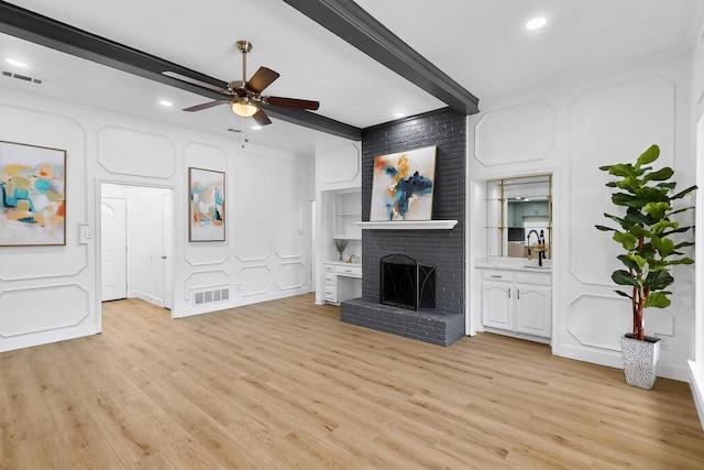 2258 Valley, Carrollton, TX 75006 - unfurnished living room with ceiling fan, light wood finished floors, a brick fireplace, beam ceiling, and recessed lighting
