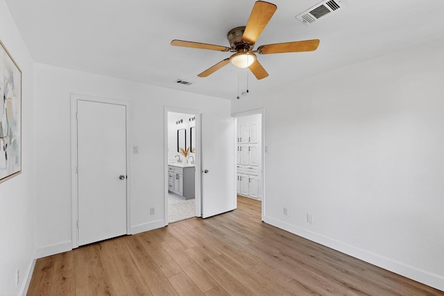 2258 Valley, Carrollton, TX 75006 - unfurnished bedroom featuring light wood-style flooring, connected bathroom, and a ceiling fan