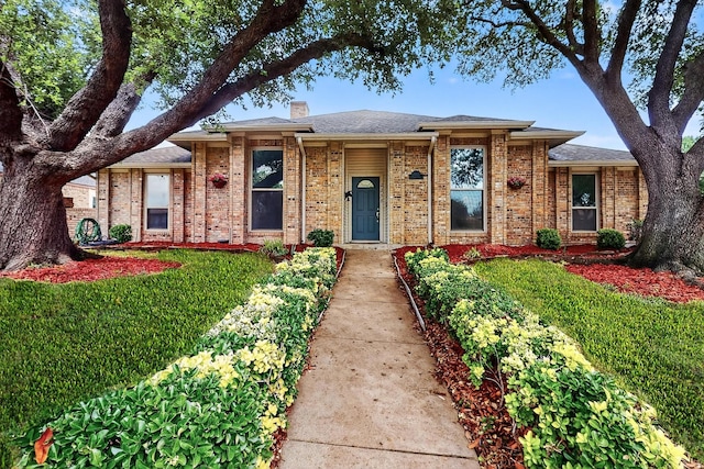 2258 Valley, Carrollton, TX 75006 - view of front facade with a chimney, brick siding, and a front lawn
