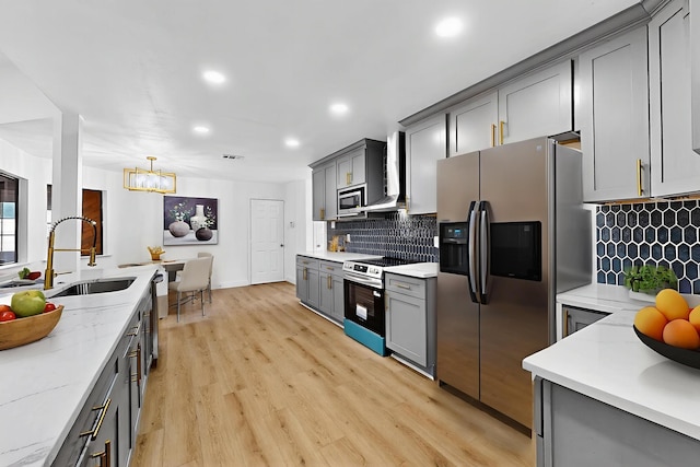 2258 Valley, Carrollton, TX 75006 - kitchen with stainless steel appliances, gray cabinetry, a chandelier, recessed lighting, and wall chimney range hood