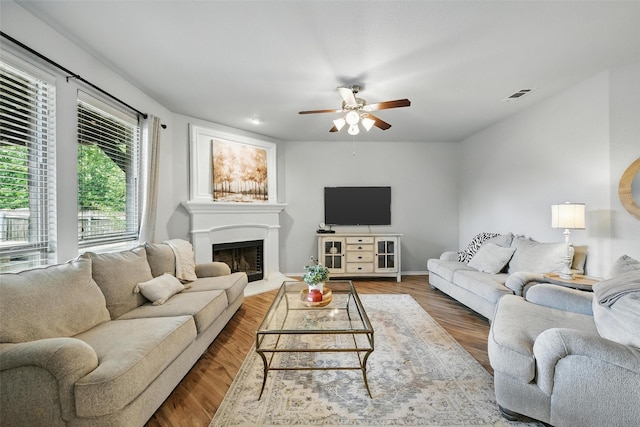 14049 Wrangler Way, Haslet, TX 76052 - living area with ceiling fan, a fireplace with raised hearth, and wood finished floors