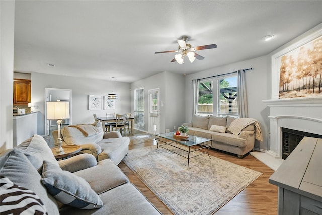 14049 Wrangler Way, Haslet, TX 76052 - living area featuring ceiling fan, a fireplace with raised hearth, and light wood-style flooring