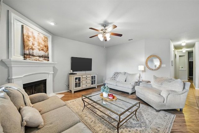 14049 Wrangler Way, Haslet, TX 76052 - living room featuring ceiling fan, a fireplace with raised hearth, and wood finished floors