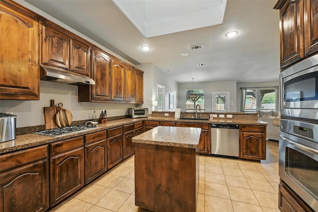 14049 Wrangler Way, Haslet, TX 76052 - kitchen with stainless steel appliances, a peninsula, under cabinet range hood, a kitchen island, and light tile patterned flooring