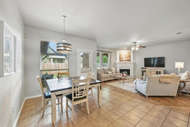 14049 Wrangler Way, Haslet, TX 76052 - dining area featuring a ceiling fan, light tile patterned floors, a fireplace, and a chandelier