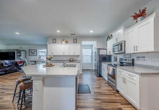 421 Atmore St, Azle, TX 76020 - kitchen with appliances with stainless steel finishes, white cabinets, a breakfast bar, recessed lighting, and dark wood-style floors