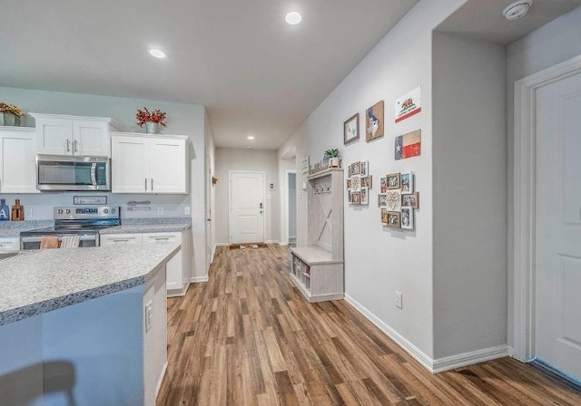 421 Atmore St, Azle, TX 76020 - kitchen featuring appliances with stainless steel finishes, light wood-style floors, white cabinetry, light countertops, and recessed lighting