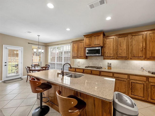 7804 Rocky Mountain Ln, Mckinney, TX 75070 - kitchen featuring stainless steel appliances, brown cabinetry, tasteful backsplash, a breakfast bar area, and recessed lighting