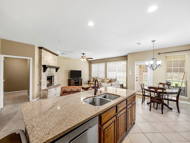 7804 Rocky Mountain Ln, Mckinney, TX 75070 - kitchen featuring a stone fireplace, dishwasher, brown cabinetry, a chandelier, and hanging light fixtures