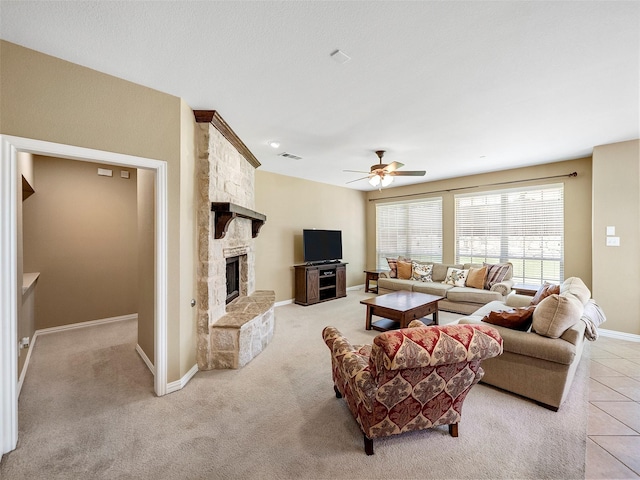 7804 Rocky Mountain Ln, Mckinney, TX 75070 - living room with a ceiling fan, a stone fireplace, light tile patterned floors, and light carpet