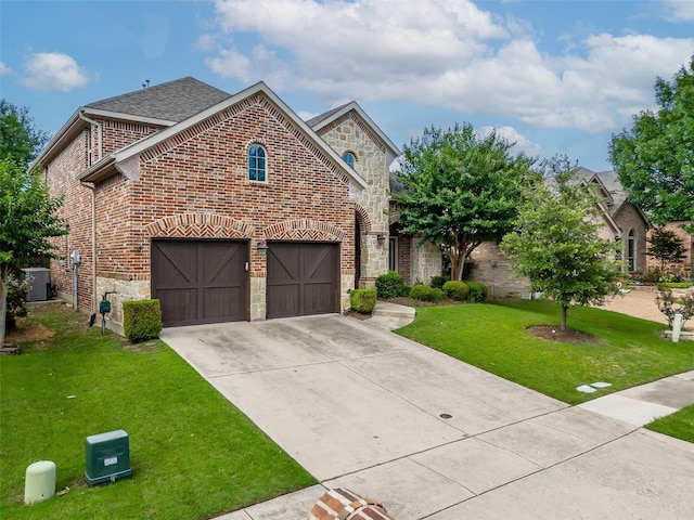 7804 Rocky Mountain Ln, Mckinney, TX 75070 - view of front of house featuring concrete driveway, a front yard, brick siding, stone siding, and an attached garage