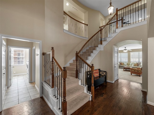 7804 Rocky Mountain Ln, Mckinney, TX 75070 - stairway with a high ceiling, wood-type flooring, a ceiling fan, and arched walkways