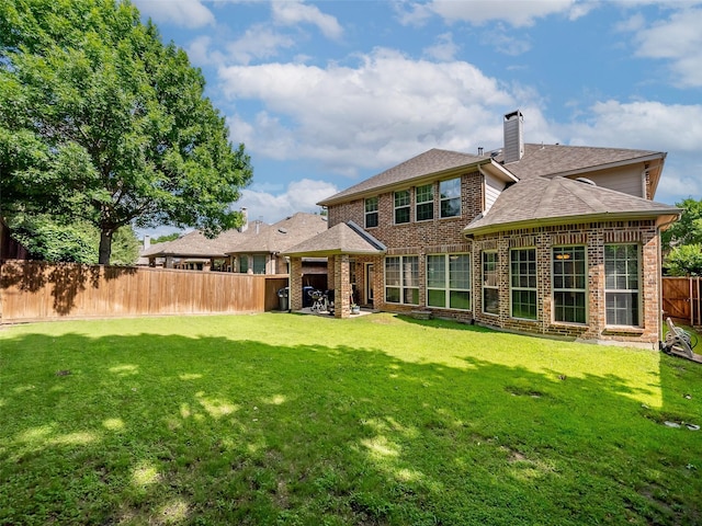 7804 Rocky Mountain Ln, Mckinney, TX 75070 - rear view of house with a fenced backyard, brick siding, a chimney, roof with shingles, and a patio area