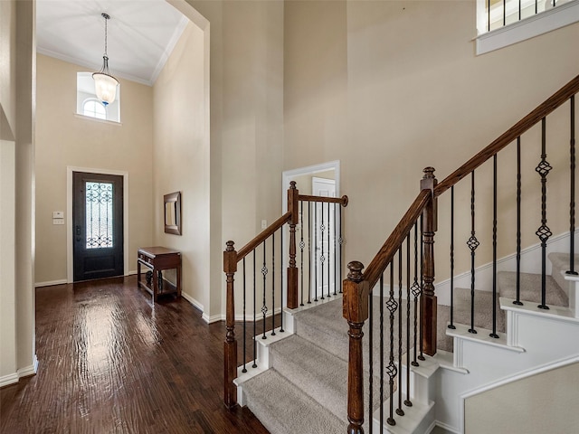 7804 Rocky Mountain Ln, Mckinney, TX 75070 - foyer entrance featuring a towering ceiling, wood finished floors, crown molding, stairway, and arched walkways