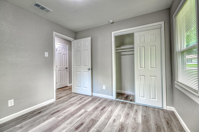 1112 Leyenda Dr, Mesquite, TX 75149 - unfurnished bedroom with wood finished floors, a closet, a textured ceiling, and a textured wall