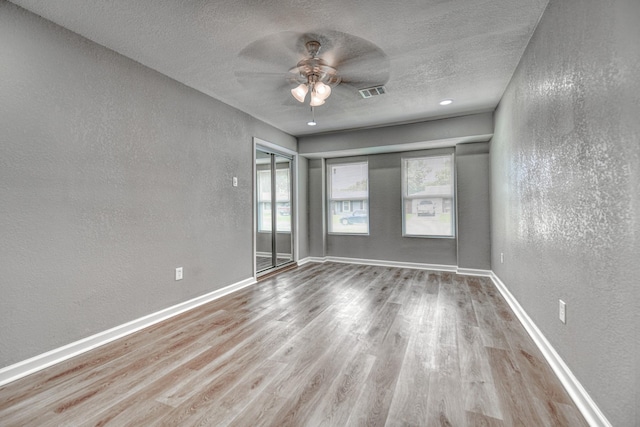 1112 Leyenda Dr, Mesquite, TX 75149 - unfurnished room with a textured wall, ceiling fan, wood finished floors, and a textured ceiling