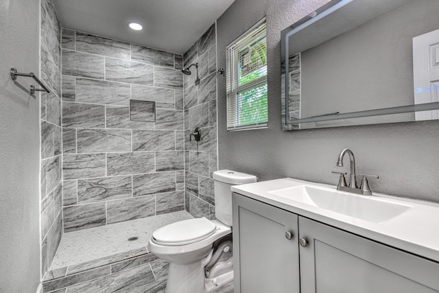 1112 Leyenda Dr, Mesquite, TX 75149 - full bathroom featuring a tile shower, vanity, a textured wall, and recessed lighting